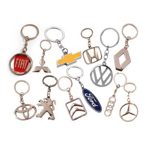 llavero metálico con logo de marcas de autos como Fiat, Ford, Chevrolet, Peugeot, Toyota y más